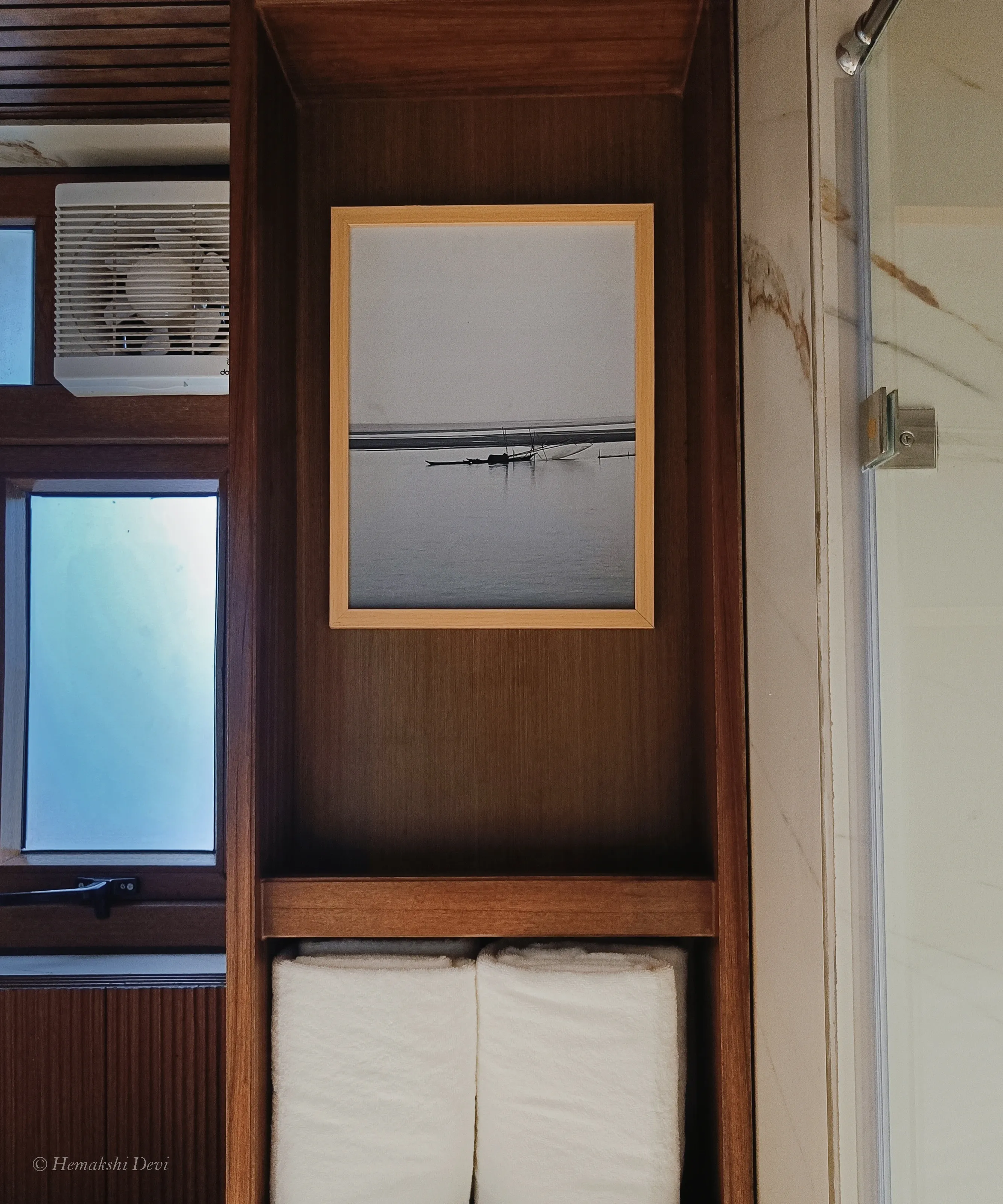 Framed woven-pattern digital artwork above the bathtub in a guest bathroom